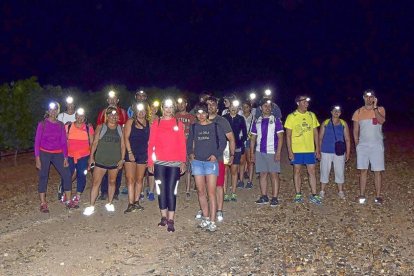 Un grupo de ‘enoturistas nocturnos’ se dirige con sus linternas frontales al Pago de Valdecuevas, este domingo.-EL MUNDO