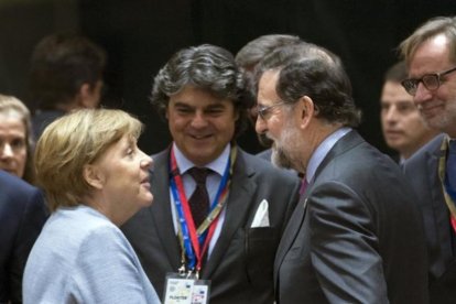 Merkel y Rajoy se saludan antes del comienzo de la cumbre.-EFE