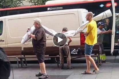 Unos hombres sacan de una furgoneta la pancarta supuestamente contraria al Rey.-VÍDEO: EL PERIÓDICO