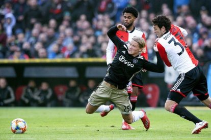 El delantero del Ajax Dolberg cae en la lucha de un balón en el partido ante el Feyenoord.-ANP