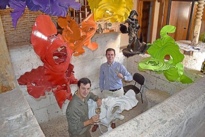 El enólogo Alberto Martínez (en primer término) y Pablo del Villar, en el interior del lagar de piedra, bajo la obra del artista Andrés Coello.-ARGICOMUNICACIÓN