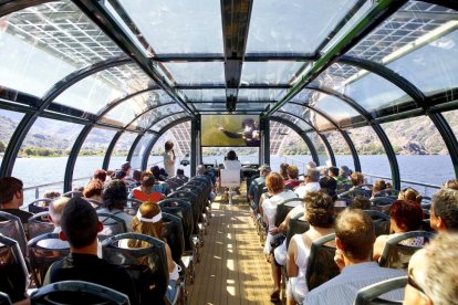 Pasajeros del catamarán que surca las aguas del lago de Sanabria observan en una pantalla las evoluciones de un submarinista.-L.P.