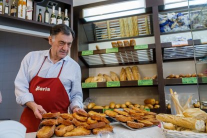 La actividad del local es frenética durante los días de Semana Santa. En la imagen, Juan José Marín muestra una bandeja de torrijas, en las que sigue la misma receta familiar de su madre. - L.P.