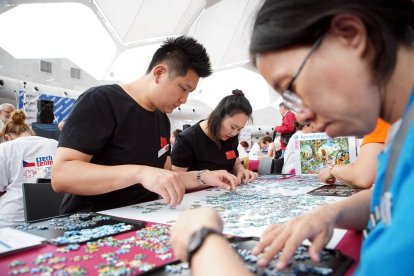 Un grupo de participantes llegados desde China trabajan en un puzzle de 1.000 piezas.-ICAL