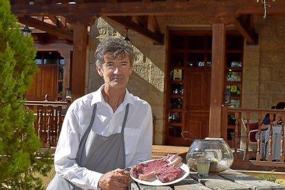 José Luis Velayos, a la entrada del establecimiento cebrereño, con un chuletón de Carne de Ávila.-ARGICOMUNICACIÓN