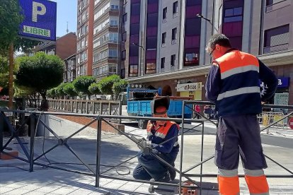 Dos operarios ultiman los detalles del primer tramo de la calle Panaderos abierto al tráfico.-J.M. LOSTAU