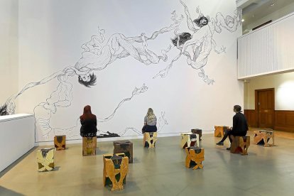 Un grupo de personas contemplan el mural creado por Aparicio, sentadas sobre sus banquetas.-REP. GRÁFICO: THE TETLEY