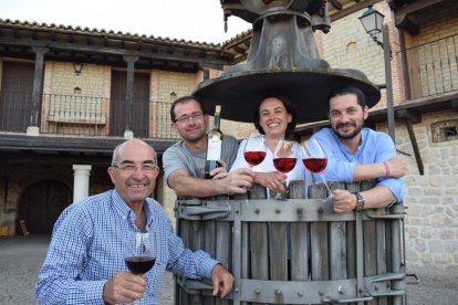 Los hermanos Alfredo, Inés y Pablo (de izquierda a derecha), dentro de una antigua prensa, junto a su padre Alfredo.-ARGICOMUNICACIÓN