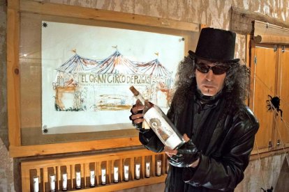 El polifacético artista Miguel Ángel Maroto, con uno de sus célebres grabados embotellados, y junto al circo de pulgas de su Taller-Galería Numen de Cabañas de Polendos (Segovia).-ARGICOMUNICACIÓN