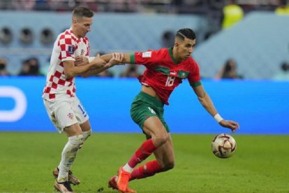 El Yamiq intenta sacar el balón jugado pero es agarrado por un jugador de Croacia antes de caer lesionado. EM