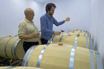 Fernando Galindo y su padre Fidencio prueban el vino de una barrica.-J.L.C.