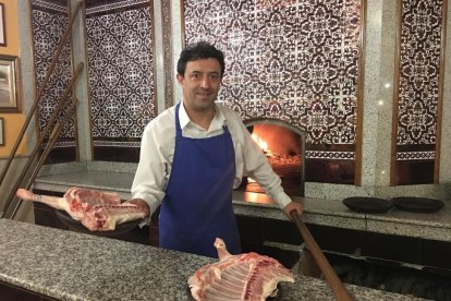 Roberto Cristóbal posa con un lechazo a punto de meterlo en el horno.-