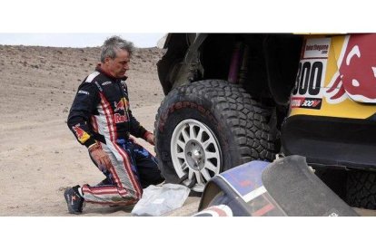 Carlos Sainz (Mini), en pleno trabajo para cambiar una rueda pinchada.-AFP / FRANCK FIFE