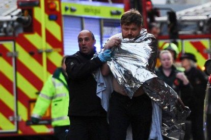 La policía asiste a un hombre herido en el ataque en el Puente de Londres, este viernes.-AFP