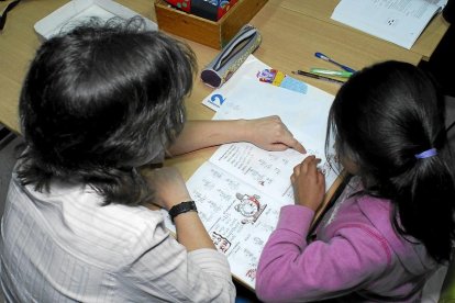 Una especialista presta apoyo escolar a una alumna, en una fotografía de archivo.-E. M.