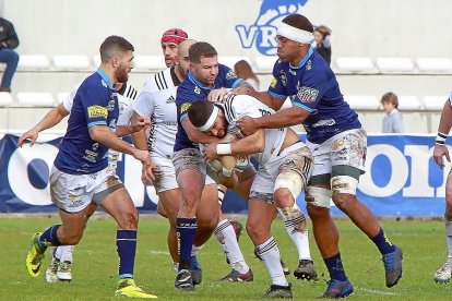 Chris Eaton y Kalokalo Gavidi intentan placar a Matt Smith en el derbi anterior.-J. M. LOSTAU