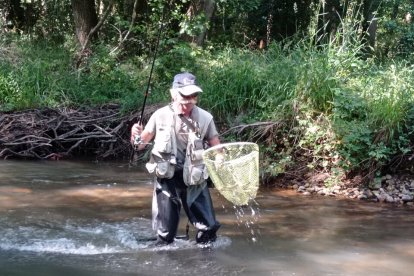 Un pescador palentino con una trucha del río Carrión recién capturada. Leonardo de la Fuente