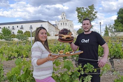 Pilar y Alberto, con dos de los platos de su comanda, entre los viñedos que se encuentran junto a La casona de La Vid, en el entorno del Monasterio .-