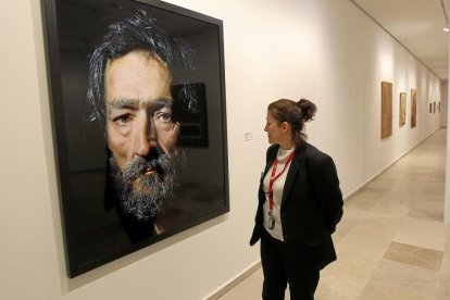 Una mujer contempla uno de los retratos de Pierre Gonnord.-J. M. LOSTAU