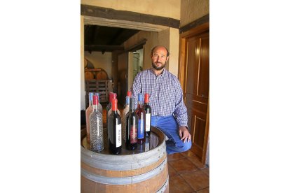 El enólogo Ildefonso Gregorio Hidalgo posa en la entrada de la bodega con sus vinos.-M.T.