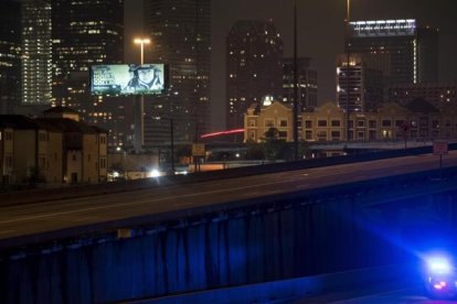 Un coche de policía patrulla las calles de Houston después del anuncio del toque de queda anunciado por el alcalde de la ciudad, Sylvester Turner-BRENDAN SMIALOWSKI