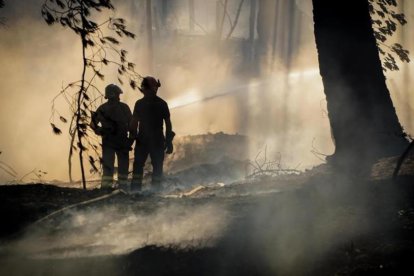 Unos bomberos tratan de controlar el fuego cerca del volcan Vesubio.-CESARE ABBATE