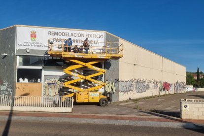 Instalación de la lona informativa en la fachada de la nave que albergará el futuro cuartel de la Guardia Civil en Arroyo de la Encomienda.- PHOTOGENIC