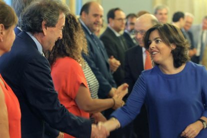 El consejero de Presidencia, José Antonio de Santiago Juárez, se saluda con la vicepresidenta del Gobierno, ayer al inicio de la conferencia.-ICAL