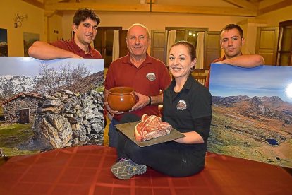 Ana, junto a Eloy (izquierda), su padre Javier y su hermano David, con las carnes rojas de la montaña y la célebre ‘olleta’.-ARGICOMUNICACIÓN