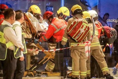 Personal sanitario traslada a una de las persona heridas en una sangrienta pelea con cuchillos en un centro comercial en Hong Kong, este domingo.-VIVEK PRAKASH (AFP)