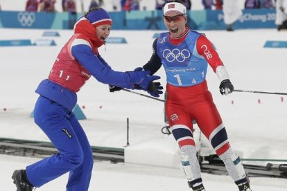 Su compañera Oestberg felicita a Bjoergen nada más cruzar la línea de meta.-EFE