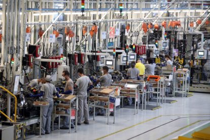 Trabajadores en una línea de trabajo de una industria automovilística