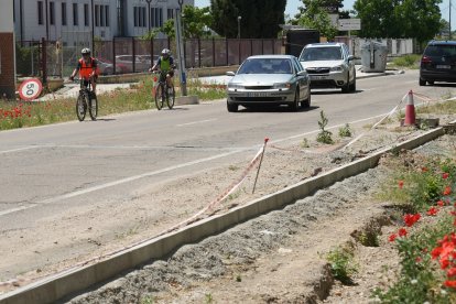 Ciclistas circulando por el arcén del camino viejo de Simancas porque la construcción del carril bici está paralizada.