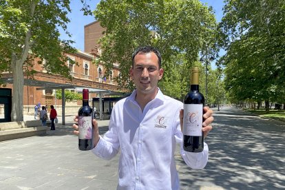 Álvaro Mélida, con dos de sus vinos Carreprado, en el parque del Salón de Palencia.