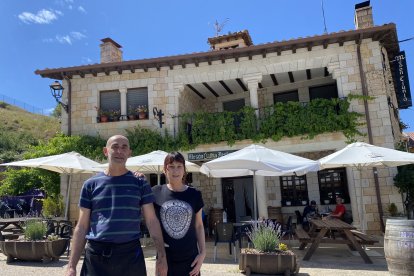 Eduardo Calvo y la cocinera Marga Rodríguez, a la puerta del Mesón Clunia, frente al yacimiento romano.