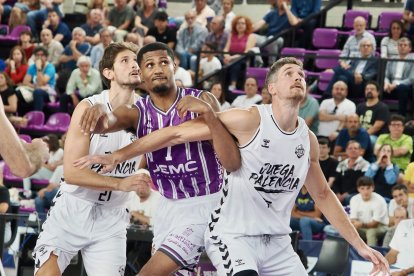 Wilson intenta zafarse del bloqueo del rebote de dos jugadores del Palencia Baloncesto.