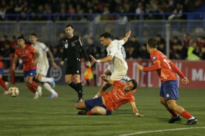 Kike intenta avanzar ante un jugador del Astur que busca obstaculizarlo.