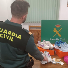 Agente de la Guardia Civil junto con el botín arrebatado a una mujer acusada de robo con fuerza.