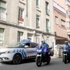 Patrulla de la Policía Municipal en la entrada del edificio okupado en el momento en que llegan dos efectivos de la Policía Nacional. J. M. LOSTAU