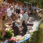Carnero ayuda a subir a la barca a un pasajero de la barca en la procesión del Carmen
