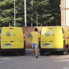 Un repartidor de Correos, en Palencia, se dispone a cargar una caja con cartas en un vehículo