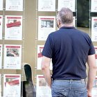 Un vecino observa las ofertas de pisos en venta y alquiler en una inmobiliaria de Valladolid. ICAL