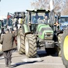 Un transeúnte muestra su apoyo a los agricultores y saluda a la conductora de un tractor que participa en la comitiva. ICAL