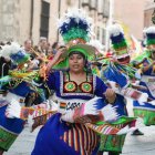 Miembros de colectivos hispanos residentes en Valladolid desfilan ante el Palacio Real ante la mirada del público.