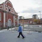 Un viandante pasa delante de las vayas y los muros que cierran las nuevas calles de Farnesio.