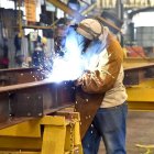Un operario suelda una estructura en una industria metalúrgica.