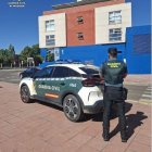 Imagen de un vehículo y un agente de la Guardia Civil