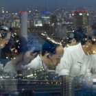 Empleados japoneses trabajando a altas horas de la noche en una empresa tecnológica con sede en Tokio.-THOMAS PETER (REUTERS)