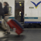 Un hombre arrastra una maleta por una estación de trenes.-E. M.
