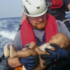 El bebé ahogado en los brazos del socorrista alemán Martin.-AP
